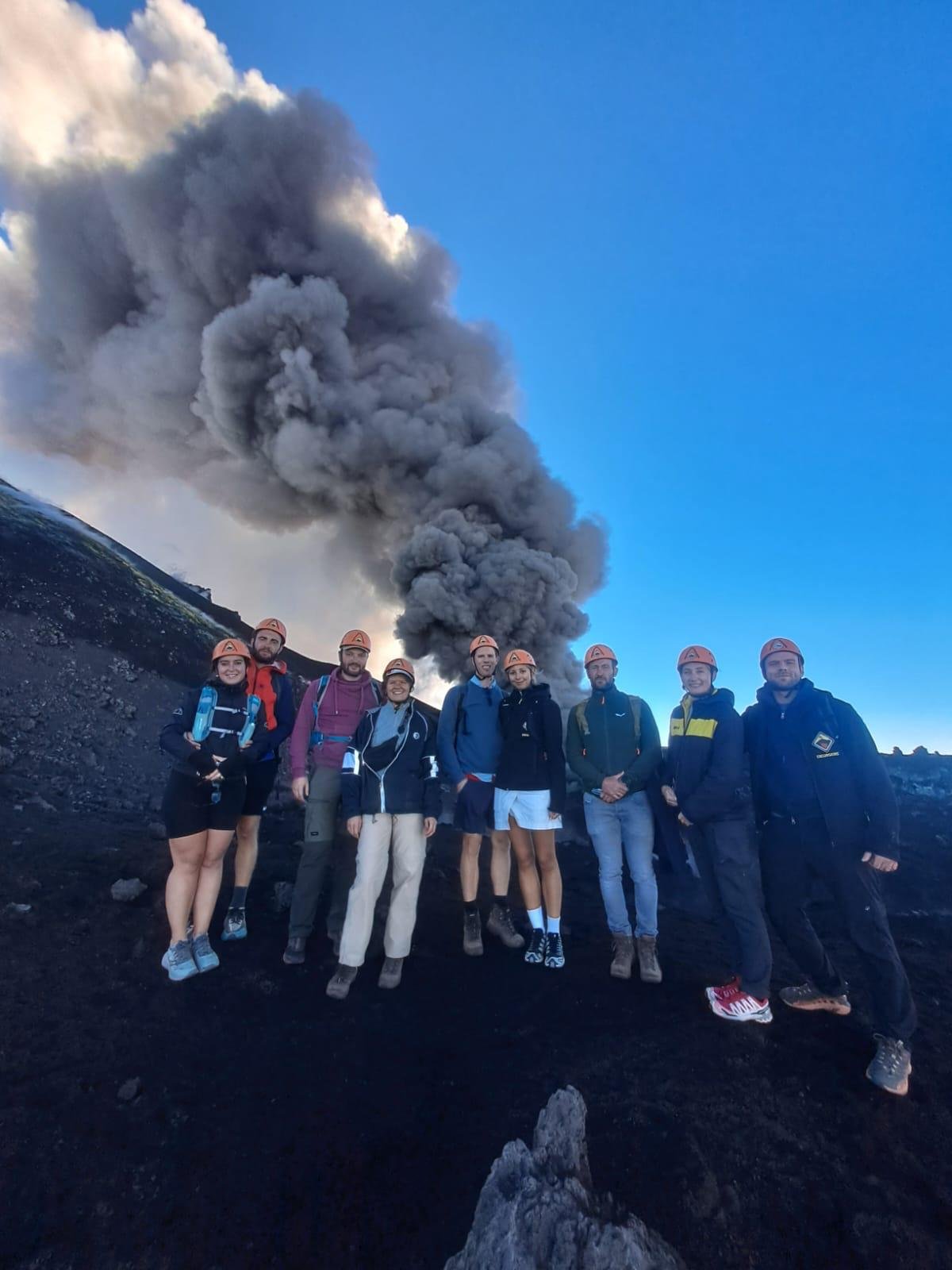 Randonneurs de Guide Vulcanologiche Etna Nord en haute altitude, avec l’émission de cendres en arrière-plan
