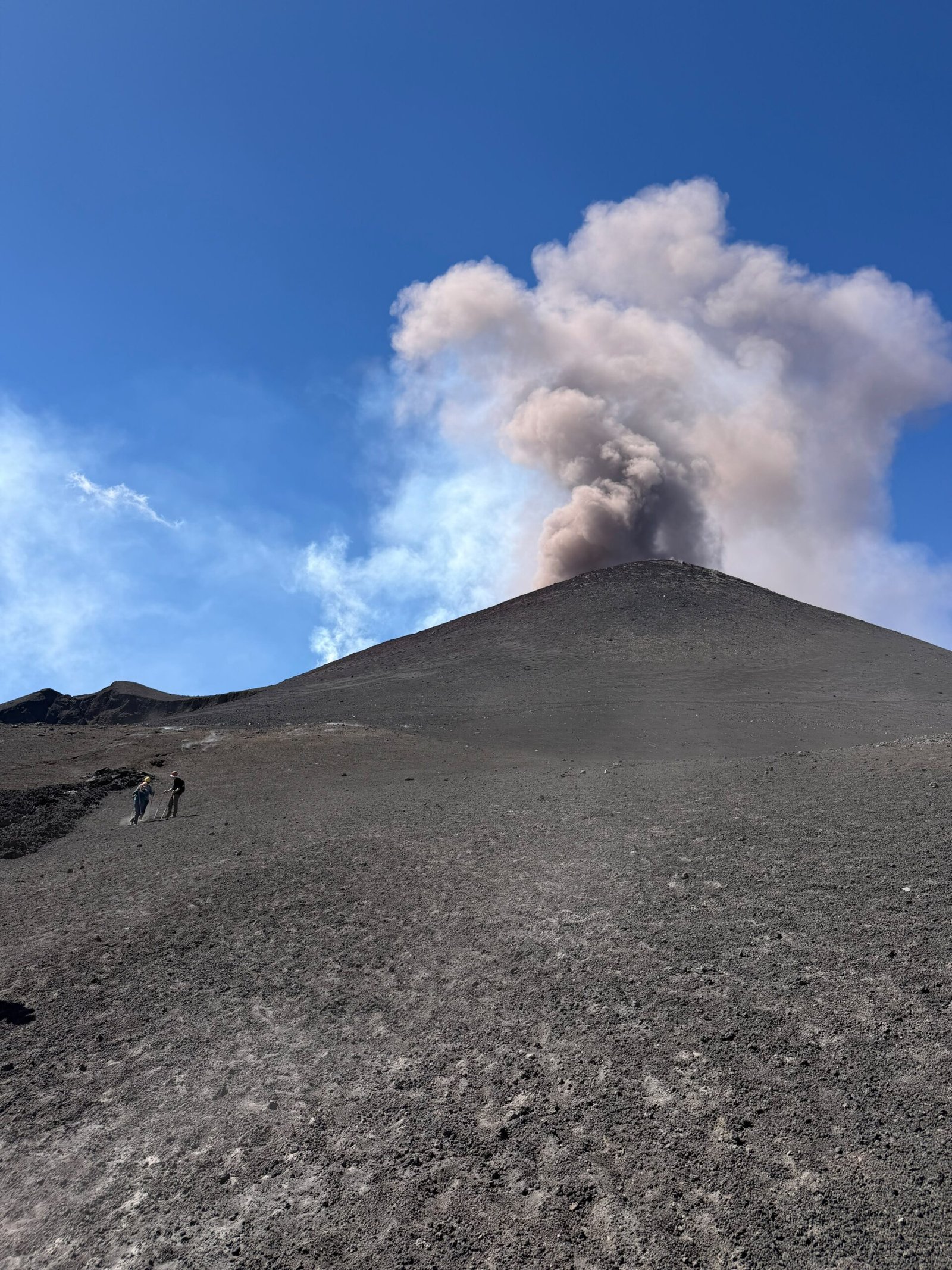 Cône sommital de l’Etna émettant des cendres, avec un sentier de haute montagne